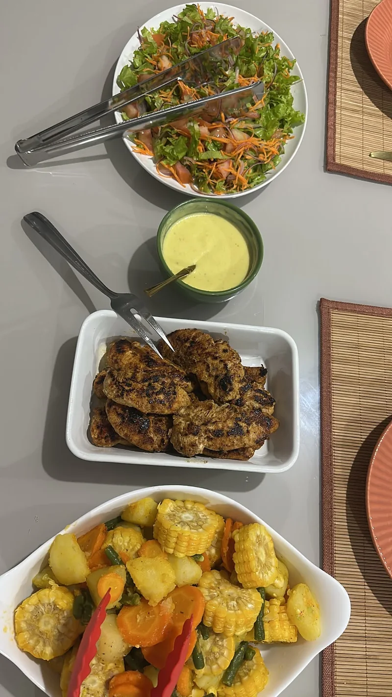 Mesa com salada, carnes e legumes variados